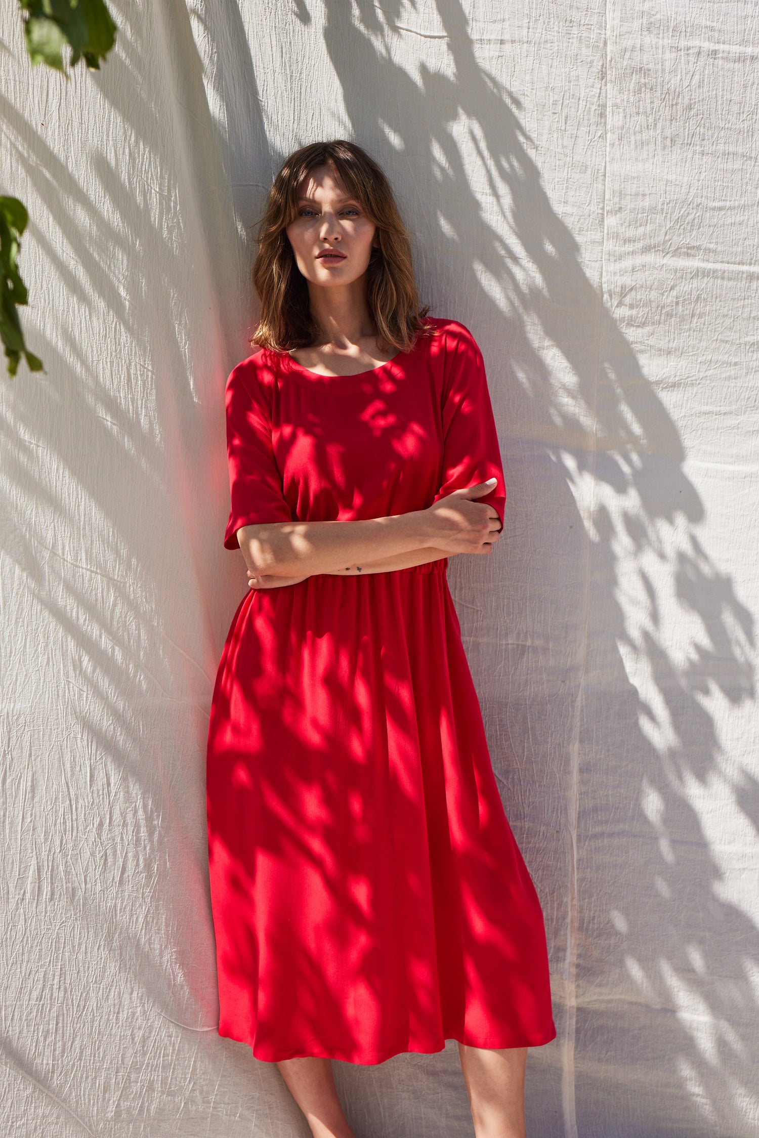 Frau mit rotem knielangem Kleid im Halbschatten