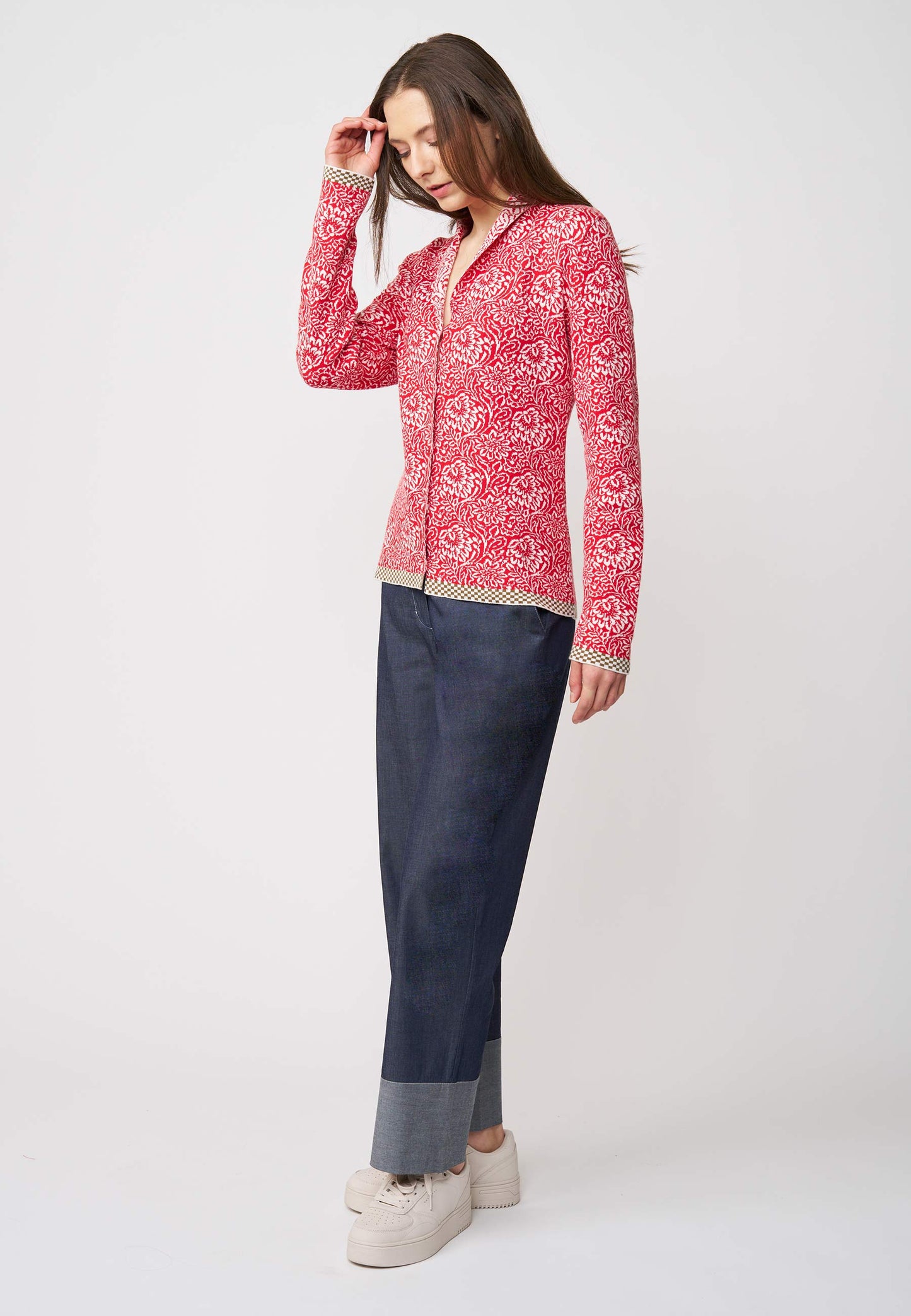 Strickjacke, Modell Jolie in tomatenrot mit weißem floralem Muster und kontrastierendem Saum, seitliche Ansicht getragen