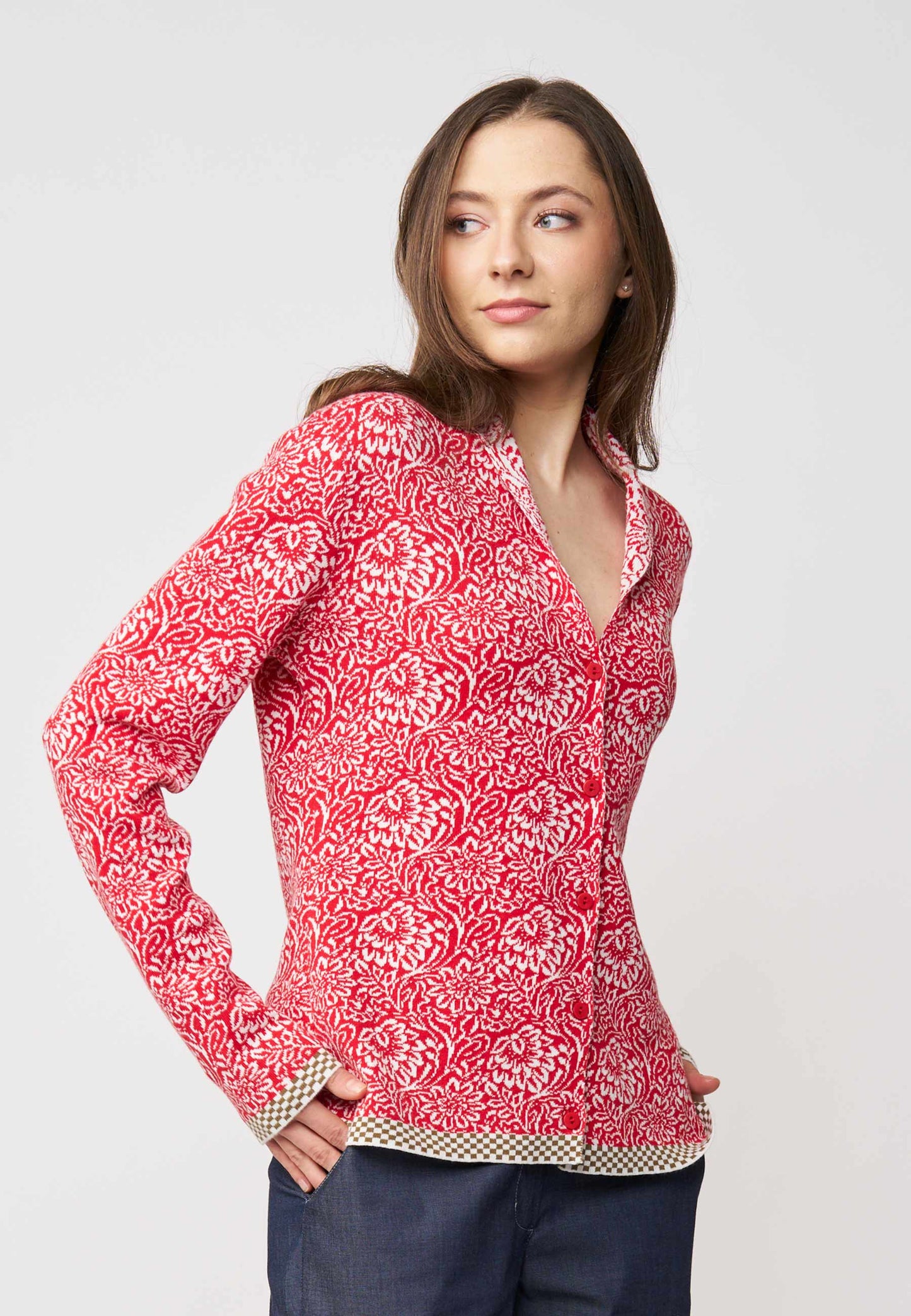 Strickjacke, Modell Jolie in Tomatenrot mit cremefarbenem floralen Muster und kontrastierendem Saum, seitliche Ansicht getragen