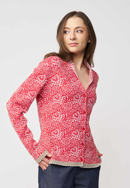 Strickjacke, Modell Jolie in Tomatenrot mit cremefarbenem floralen Muster und kontrastierendem Saum, seitliche Ansicht getragen
