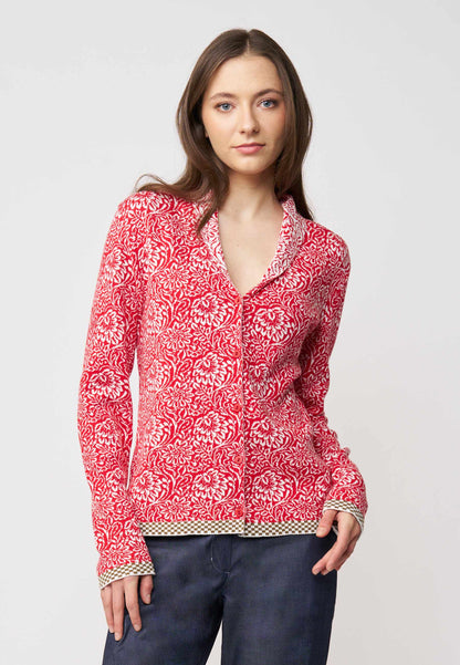 Strickjacke, Modell Jolie in leuchtendem Rot mit floraler Musterung und kontrastierendem Saum, frontale Ansicht getragen