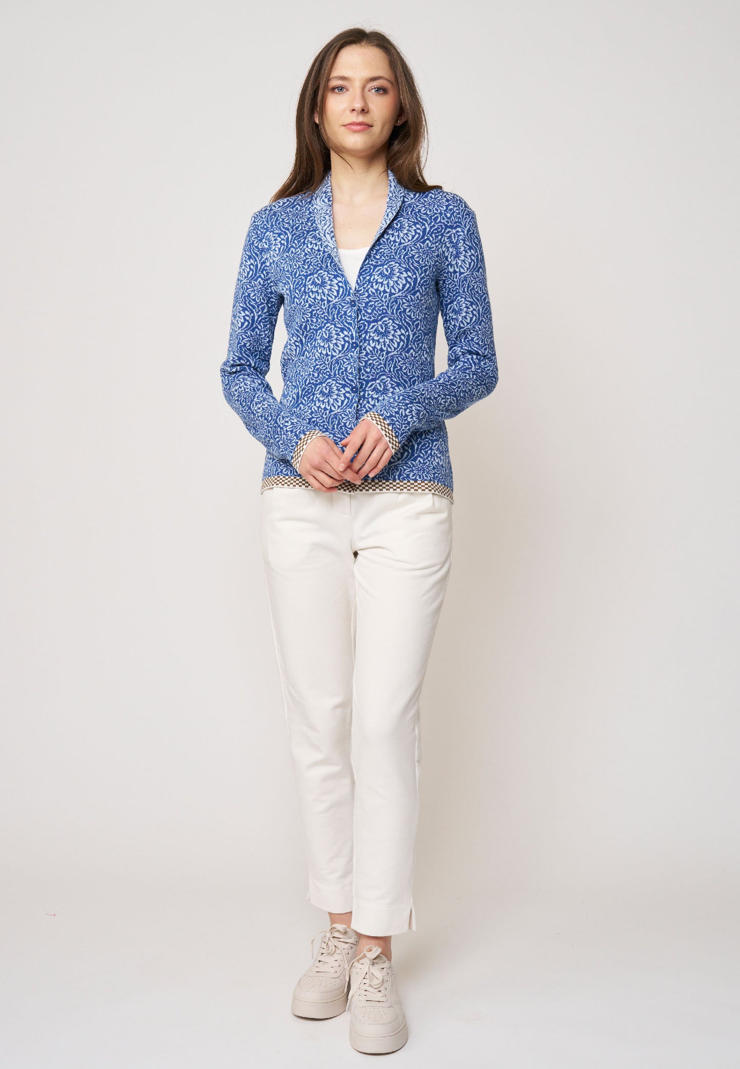 Strickjacke, Modell Jolie in Blau mit floralem Muster und gemusterter Saumkante, frontale Ganzkörperaufnahme getragen