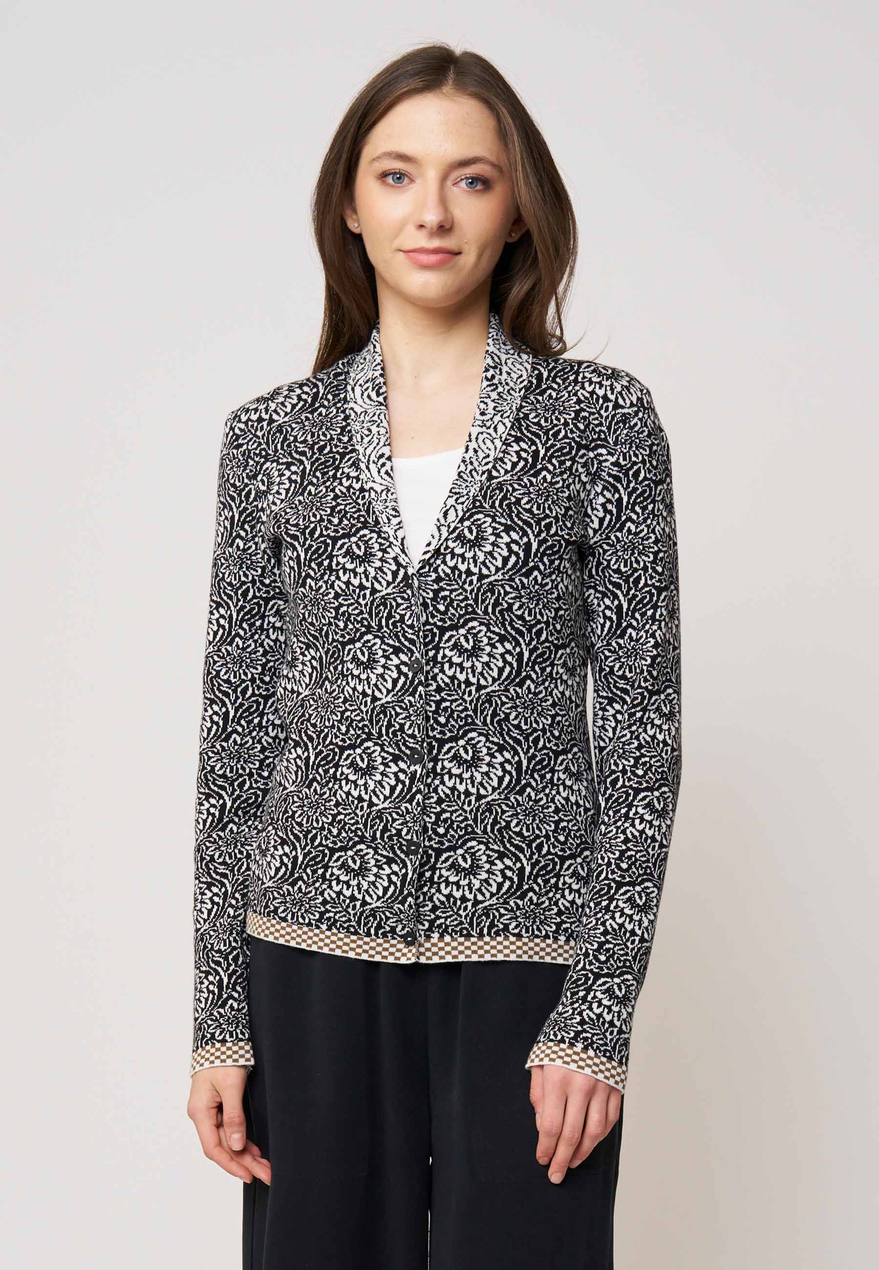 Strickjacke, Modell Jolie in schwarz-ecru mit floralem Muster und kontrastierendem Saum, frontal getragen