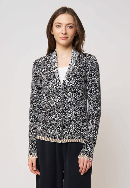 Strickjacke, Modell Jolie in schwarz-ecru mit floralem Muster und kontrastierendem Saum, frontal getragen