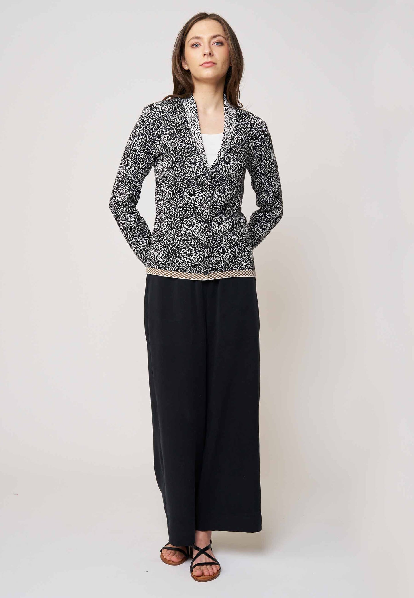 Strickjacke, Modell Jolie in Schwarz mit weißem floralen Muster und beigem Saum, Frontansicht getragen
