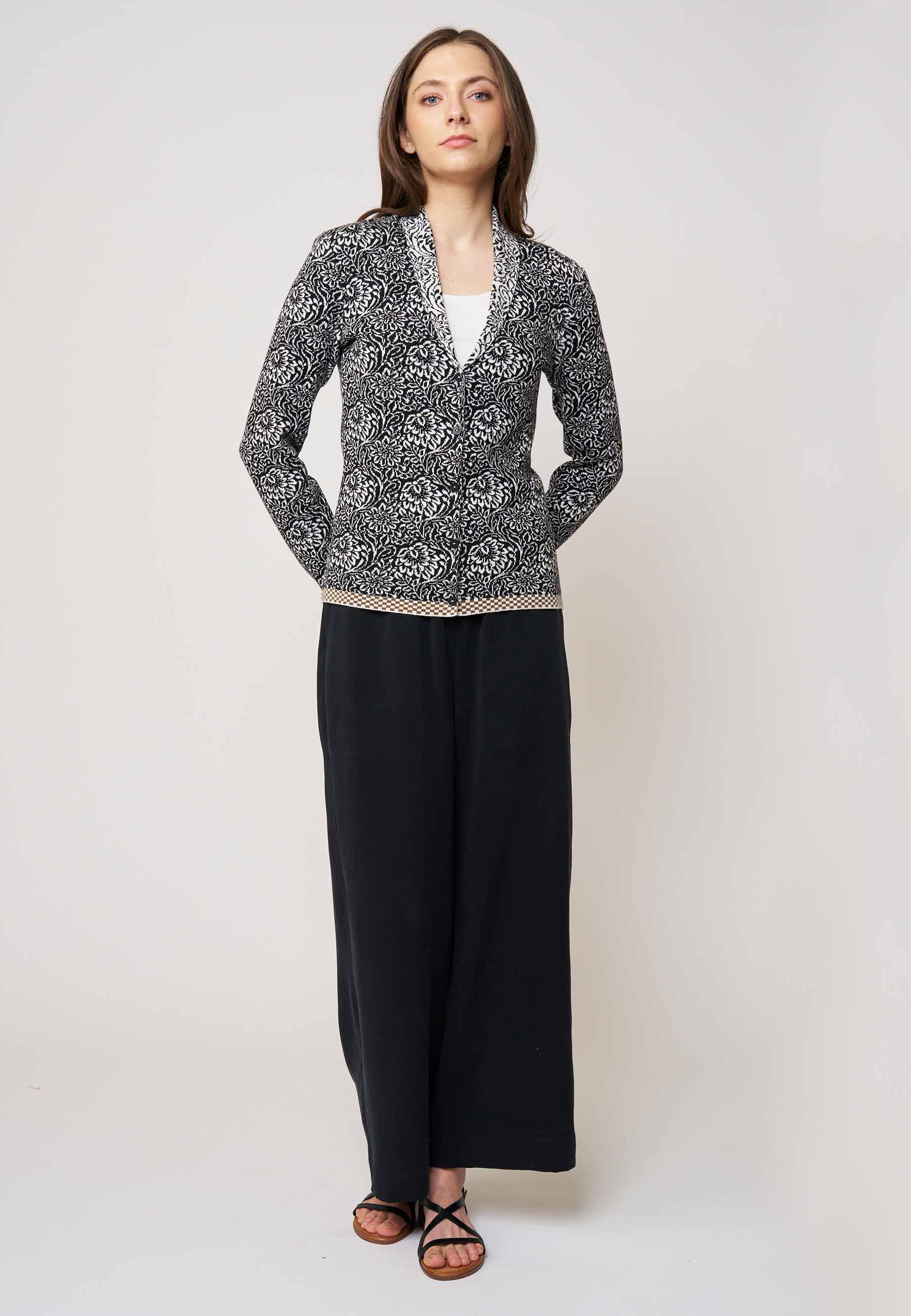 Strickjacke, Modell Jolie in Schwarz mit weißem floralen Muster und beigem Saum, Frontansicht getragen