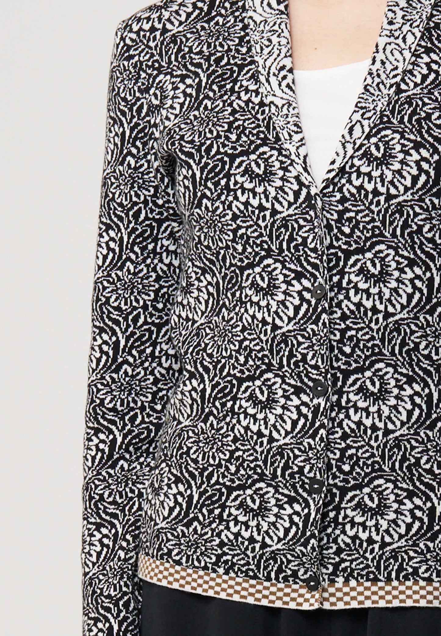 Strickjacke, Modell Jolie in Schwarz mit weißem floralen Muster und kariertem Saum, Frontansicht getragen
