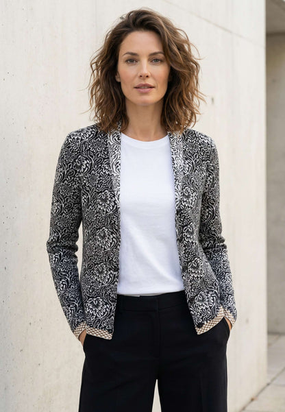Strickjacke, Modell Jolie in schwarz-ecru mit floralem Muster und kontrastierendem Saum, frontal getragen