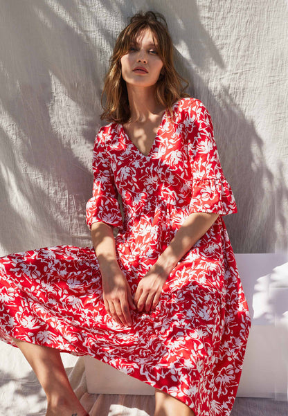 Kleid, Modell Antonia in lebhaftem Rot mit weißem Blumenmuster, V-Ausschnitt und locker fallendem Schnitt, sitzend fotografiert