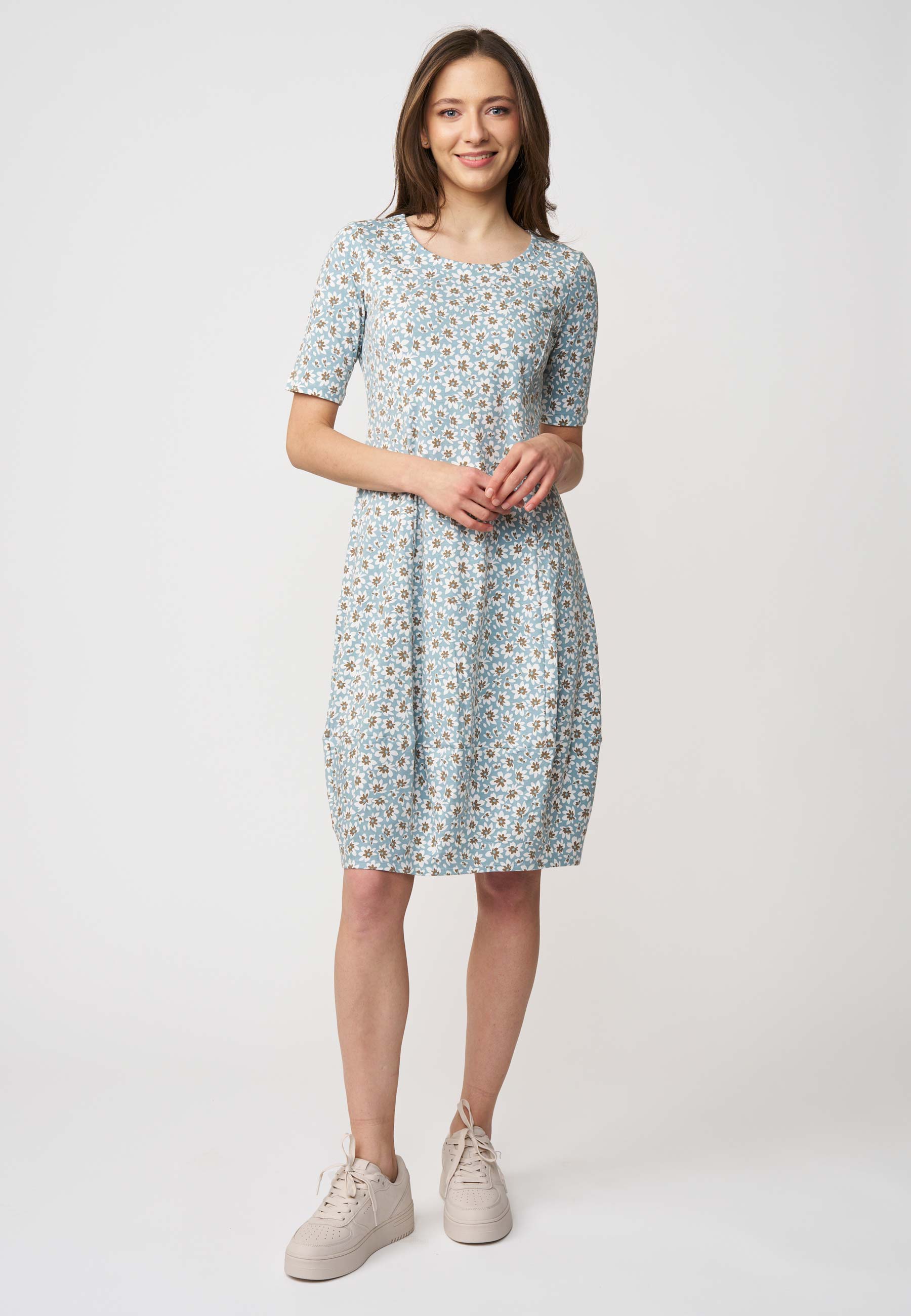 Kleid, Modell Miju in zartem Hellblau mit floralem Allover-Muster und halblangen Ärmeln, frontal getragen von Modell.