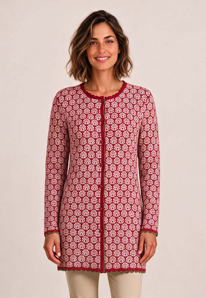 Frau trägt Jacke Eva, Modell lang, mit rotem Blumenmuster und beiger Hose vor hellem Hintergrund