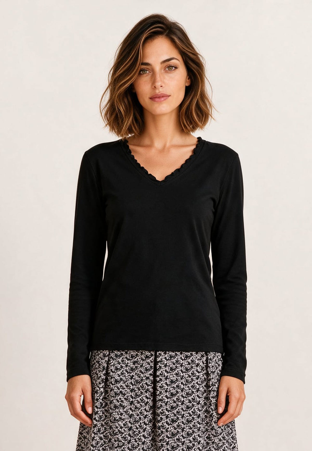Shirt, Modell Conny in Schwarz an Frau mit gemusterter Hose vor hellem Hintergrund