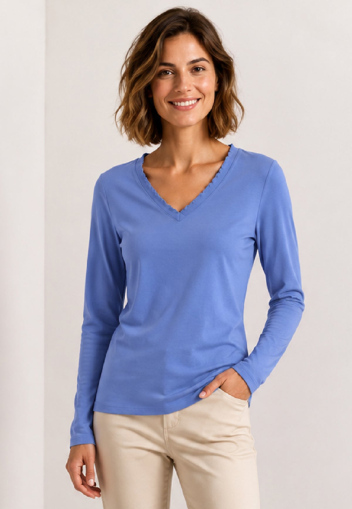 Shirt, Modell Conny in Blau an lächelnder Frau mit beiger Hose vor hellem Hintergrund