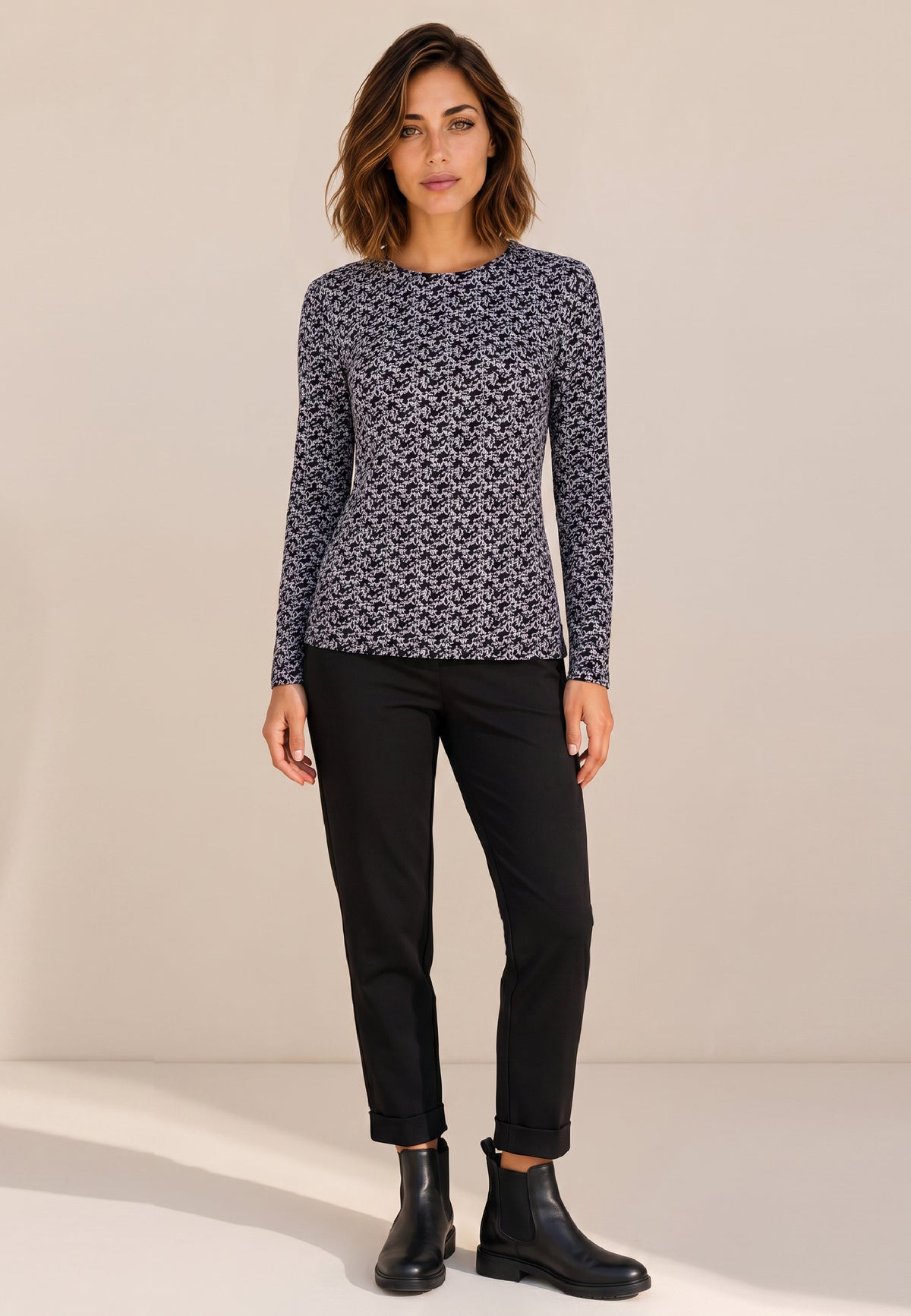 Shirt, Modell Nina mit schwarz-weißem Muster an Frau mit schwarzer Hose und schwarzen Boots