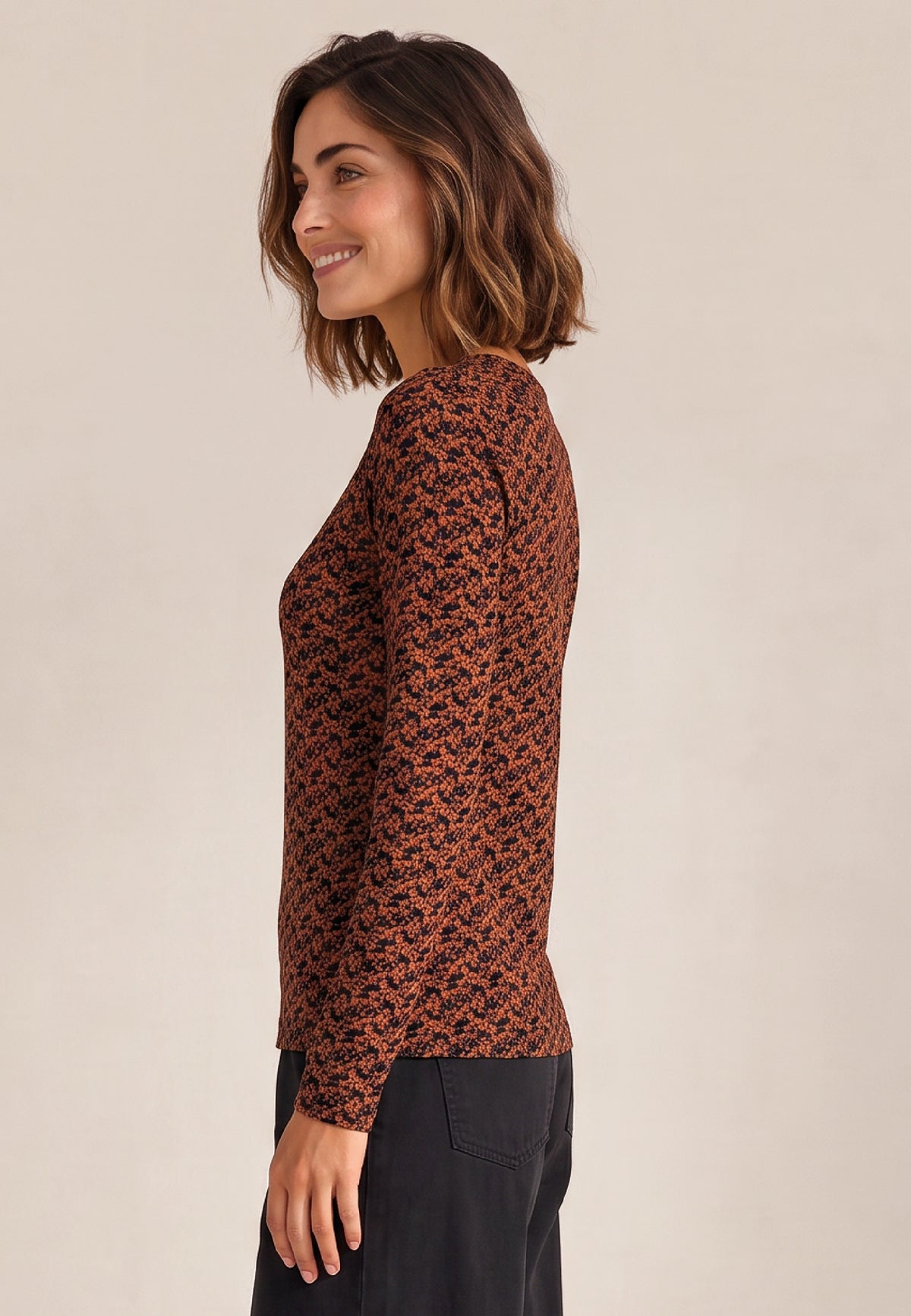 Shirt, Modell Nina mit rostbraunem Muster an lächelnder Frau im Profil und schwarzer Hose