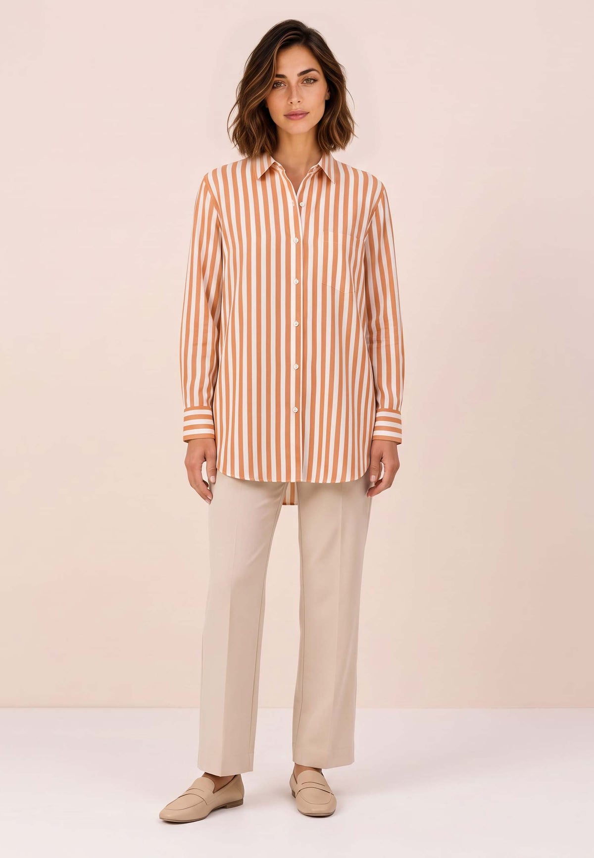 Bluse, Modell Arden mit orange-weißen Streifen an Frau mit heller Hose