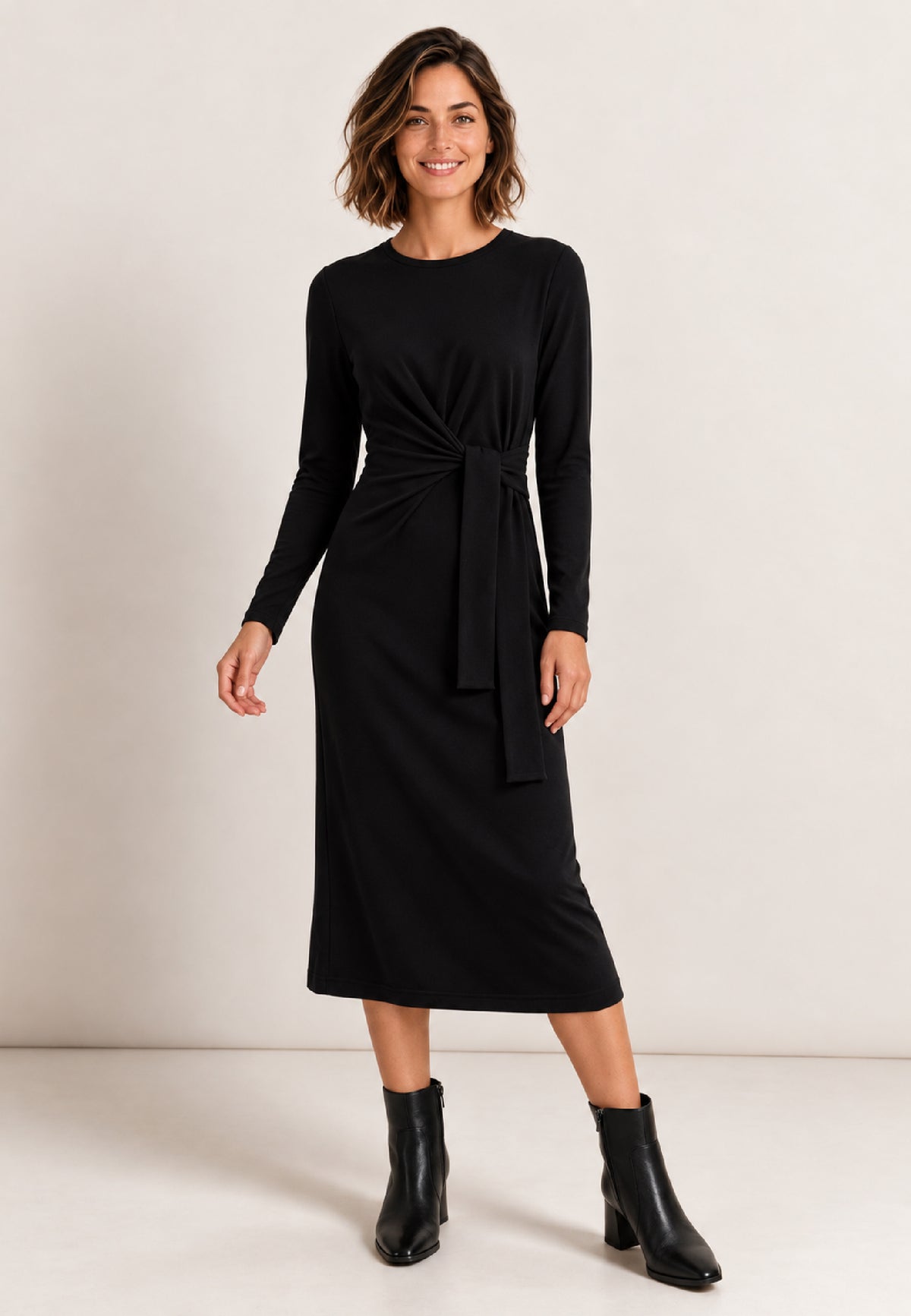 Kleid, Modell June in Schwarz an Frau mit schwarzen Stiefeln vor hellem Hintergrund