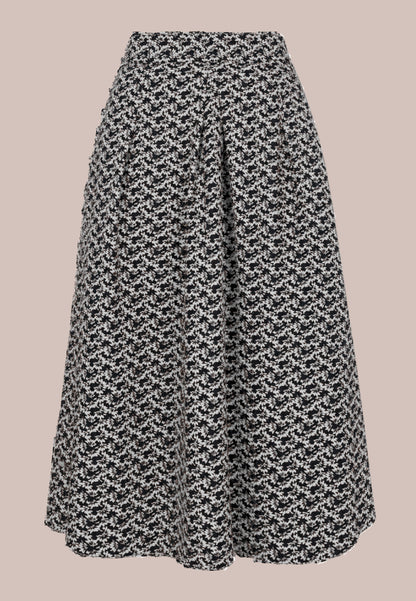 Rock, Modell Elsa mit schwarz-weißem Muster und ausgestellter Silhouette vor roséfarbenem Hintergrund