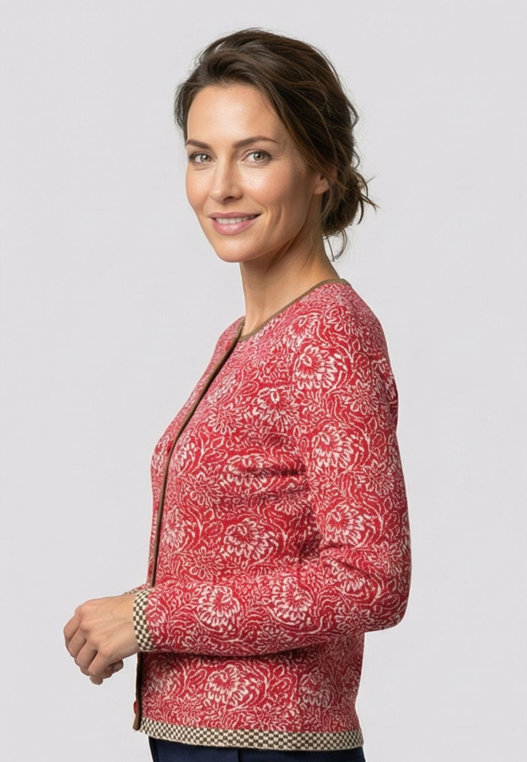 Strickjacke, Modell Lena in Rot mit floralem Muster und kontrastierendem Zierabschluss, seitliche Ansicht getragen