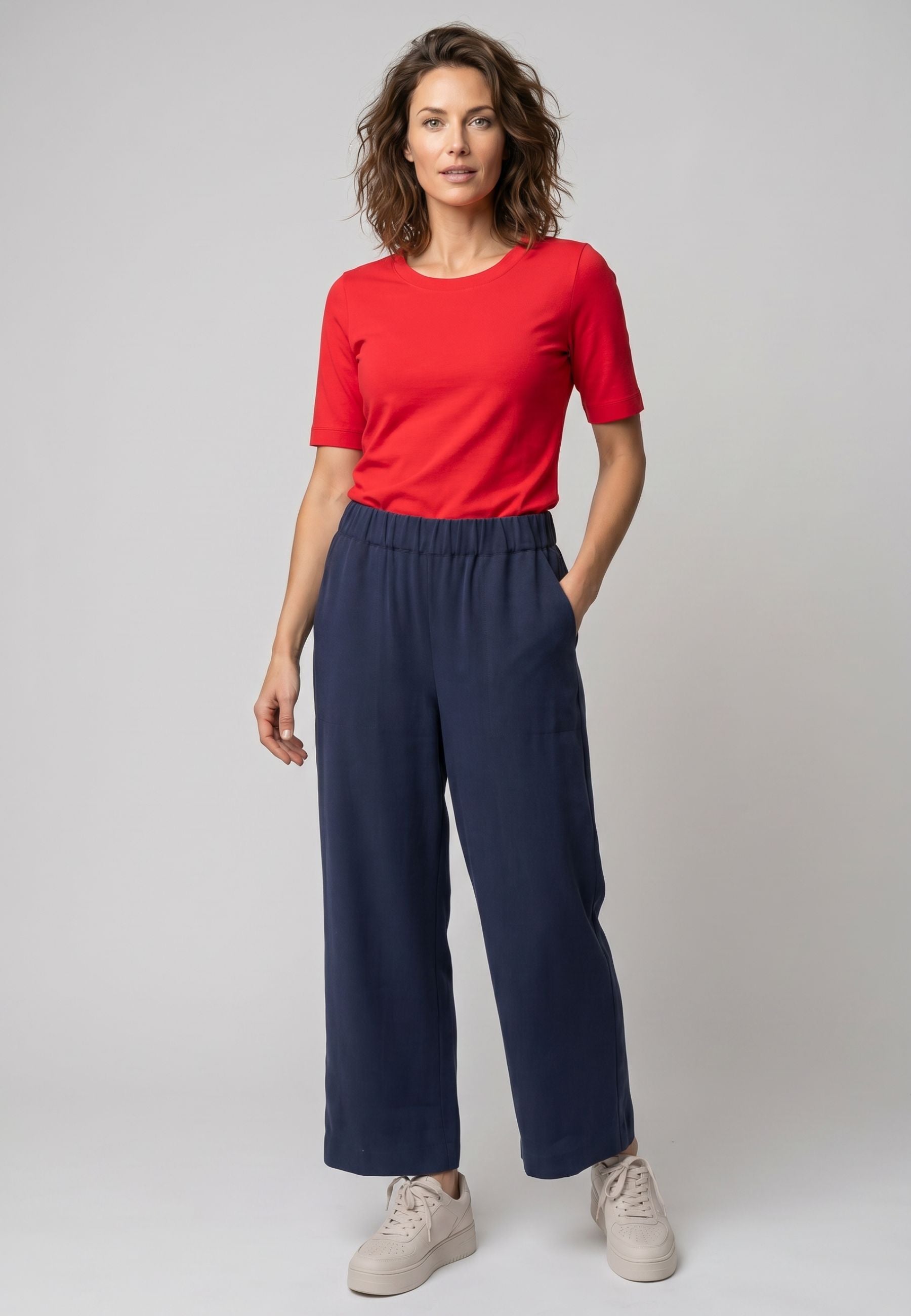 Hose aus Lyocell, Modell Jarina in marineblau mit weitem Bein und Gummibund, stehend vor grauem Hintergrund getragen