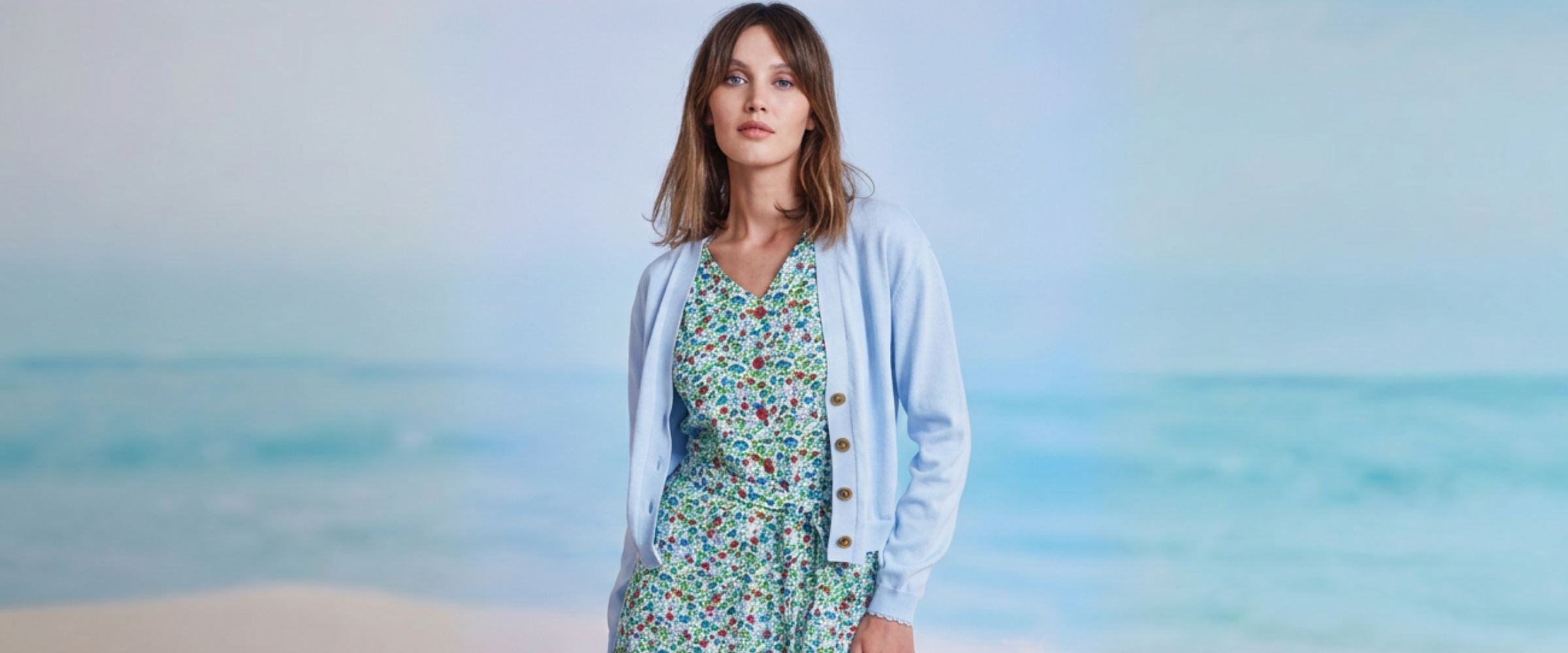 Frau mit Blümchenkleid und hellblauem Jäkchen