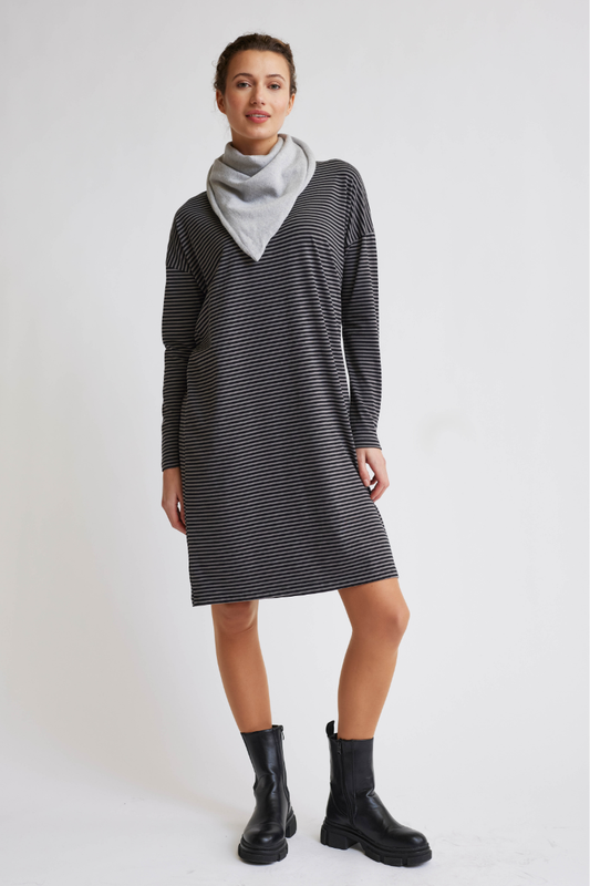 Frau trägt Kleid, Modell Lia in schmal gestreiftem Design mit langen Ärmeln und grauem Halstuch vor hellem Hintergrund